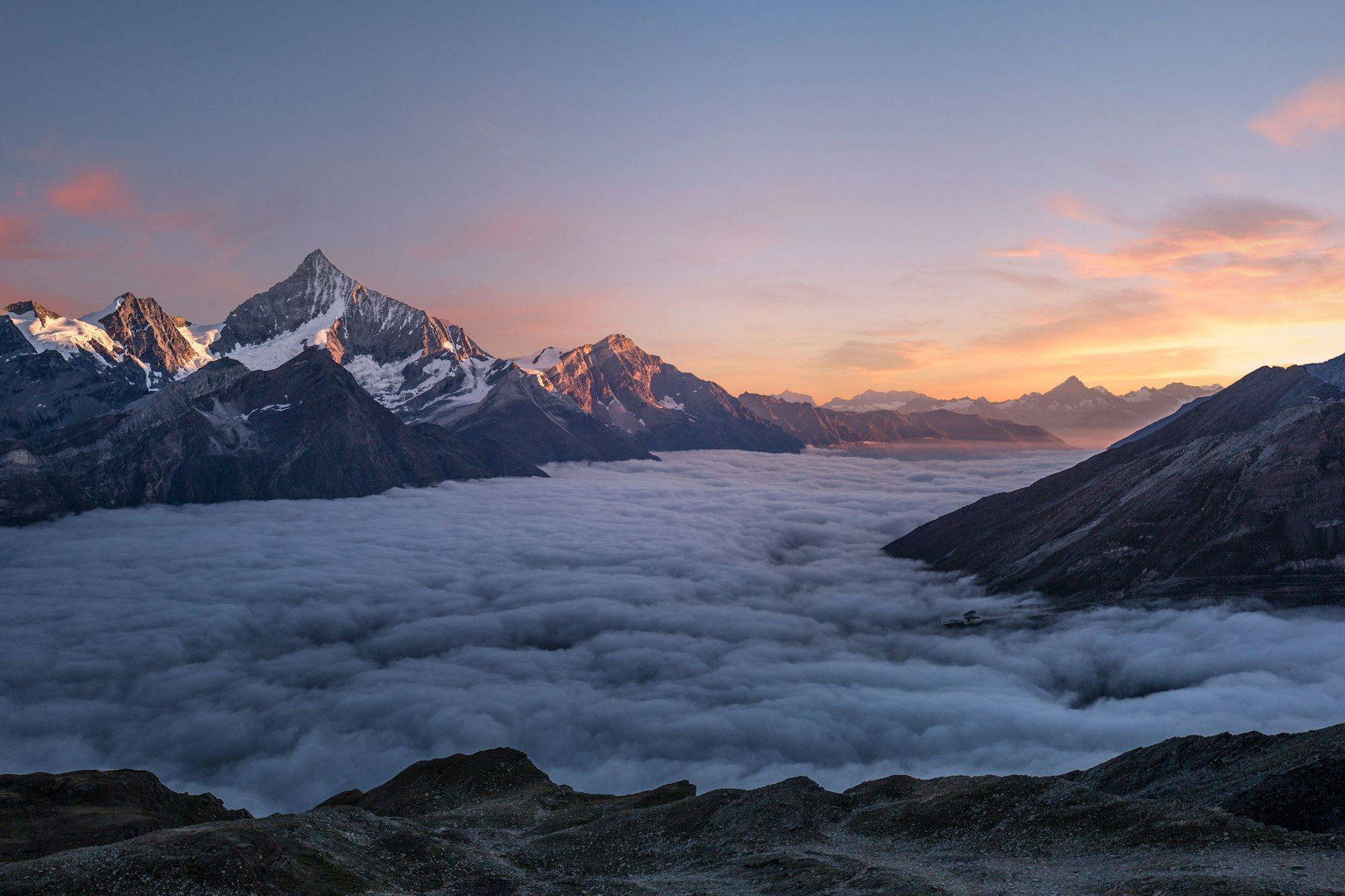 Mountain peaks above the clouds at sunrise